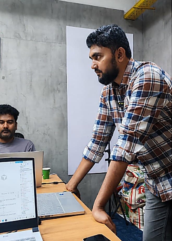A Sirah Digital engineer reviewing work at a colleague’s desk