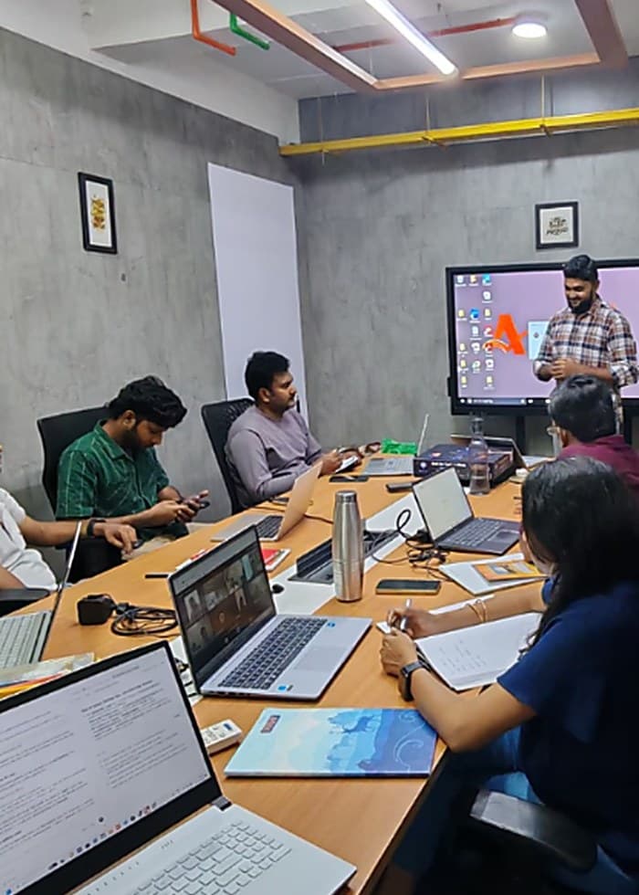 The team in a boardroom session around a shared screen