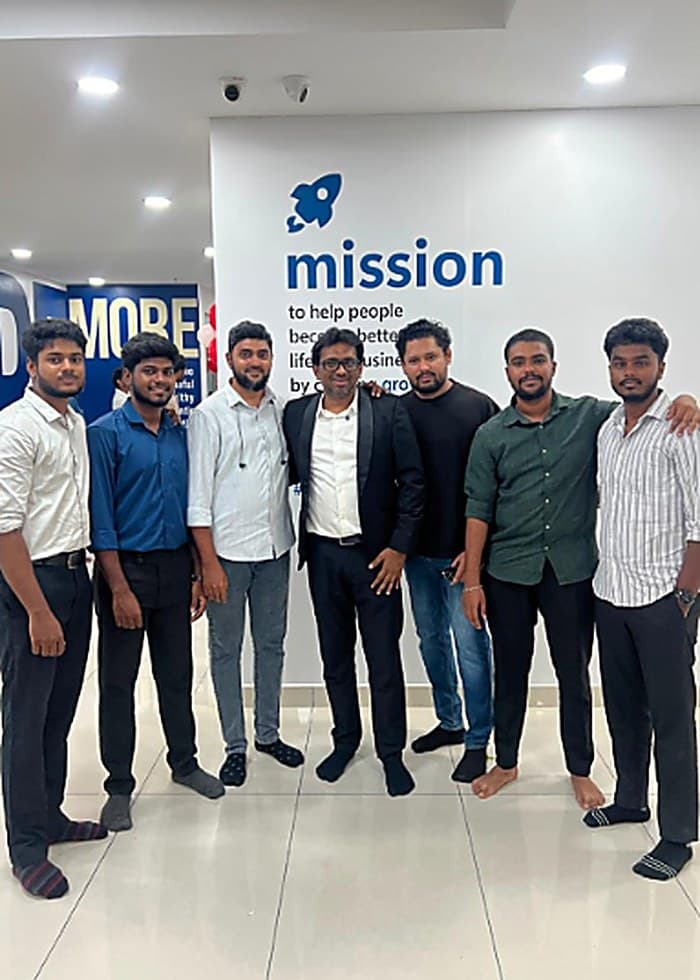 The Sirah Digital team gathered in front of a company mission wall