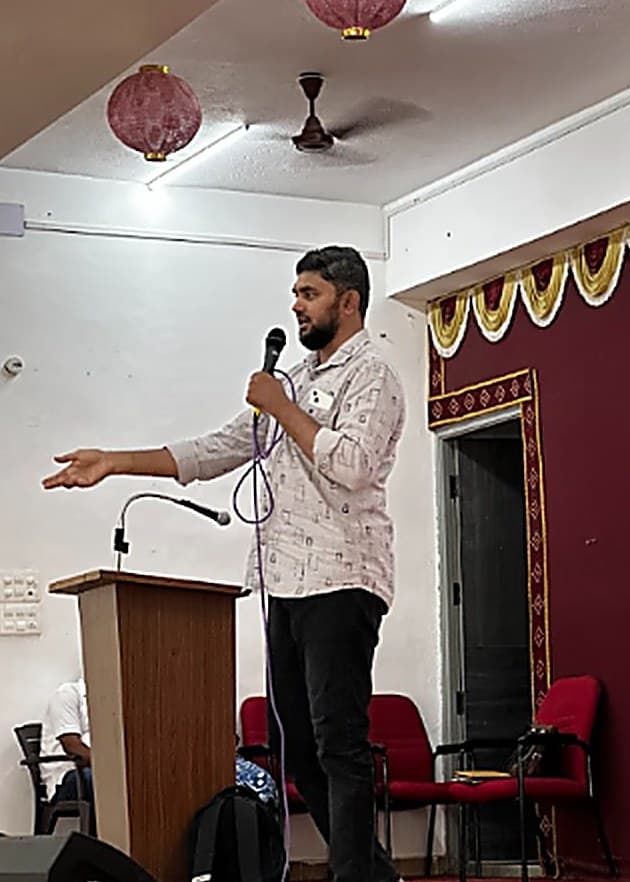 A Sirah Digital speaker addressing an audience with a microphone