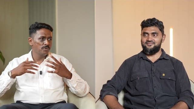 Two men seated in conversation on an interview set